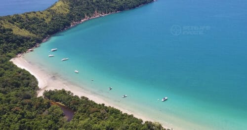 Praia das Palmas na Ilha Anchieta em Ubatuba vista aérea com barcos e águas cristalinas, próxima das praias do Engenho, Presídio e Praia do Sul no Parque Estadual da Ilha Anchieta